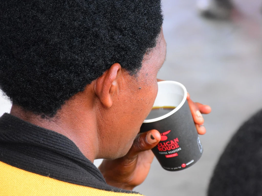 a farmer in Rwanda tasting Pelican Rouge coffee